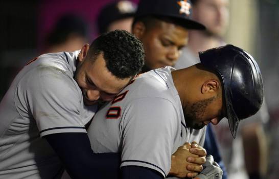El jugador de los Astros de Houston Martín Maldonado (derecha) recibe el abrazo de su compañero Carlos Correa tras sacudir un jonrón solitario en el sexto inning del juego de la MLB que enfrentó a su equipo con los Angelinos de Los Ángeles, el 21 de septiembre de 2021, en Anaheim, California. (AP/Marcio José Sánchez)
