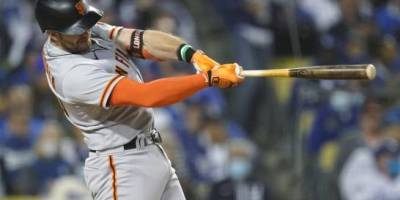 El jugador de los Gigantes de San Francisco Evan Longoria pega un jonrón solitario contra los Dodgers de Los Ángeles en el quinto inning del tercer juego de su serie divisional de la Liga Nacional, el lunes 11 de octubre de 2021, en Los Ángeles, Estados Unidos. (AP/Ashley Landis)