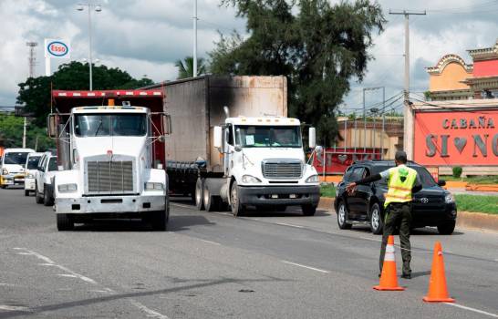 Agente de Digesett detiene camiones para revisar sus permisos en la autopista 30 de Mayo.