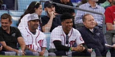 El jardinero dominicano Juan Soto, segundo desde la derecha, y el agente Scott Boras, a su derecha, se sientan en las gradas del Dodger Stadium en el partido entre los Cardenales y Los Ángeles el miércoles 6 de octubre del 2021. (AP Photo/Marcio Jose Sanchez)